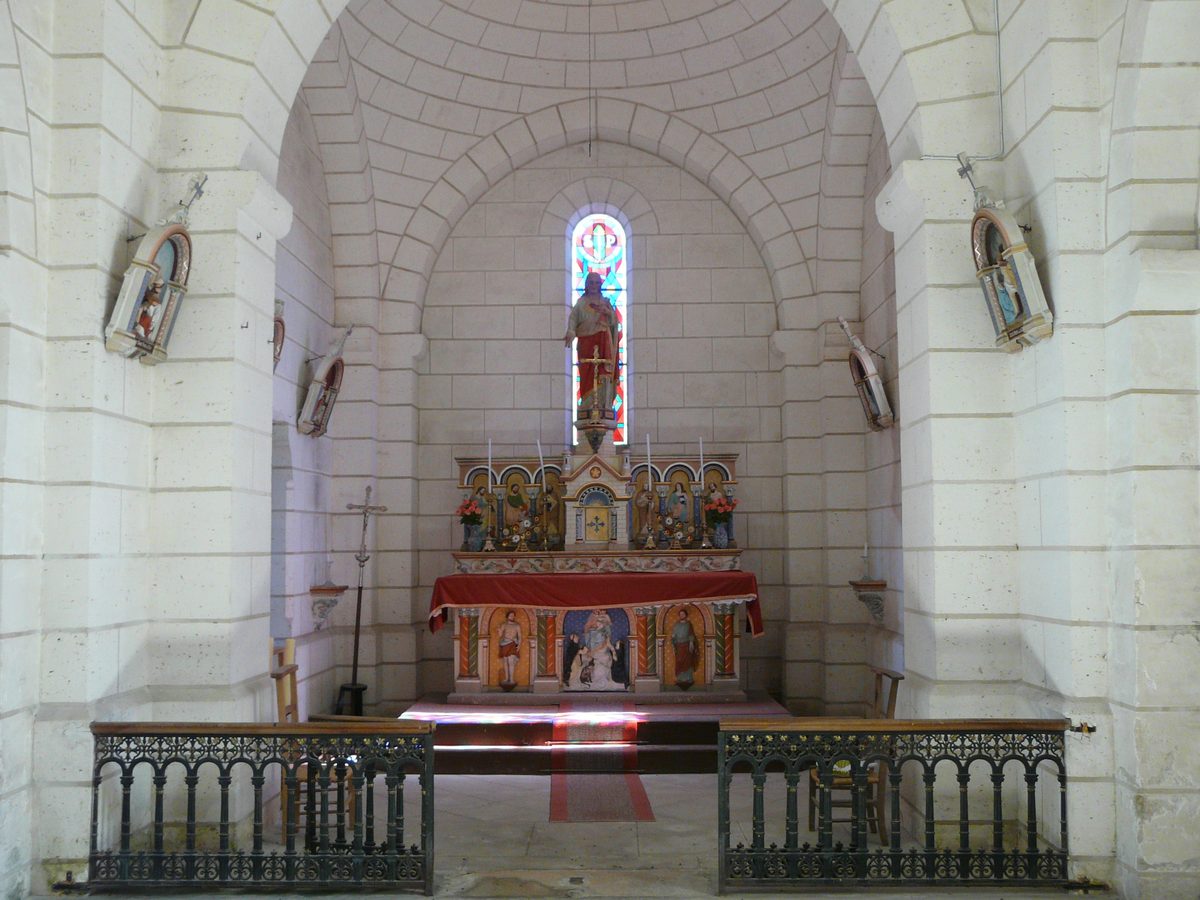 Chœur voûté de l’église avec son retable, sa statue polychrome et son vitrail