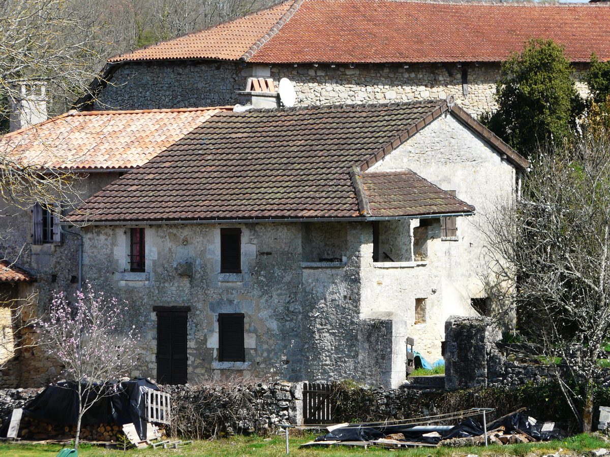 Ancienne maison périgourdine en pierre avec toiture de tuiles et grange attenante